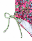 Close-up of a fabric detail with a bright pink floral print, a mint green drawstring tied in a bow.