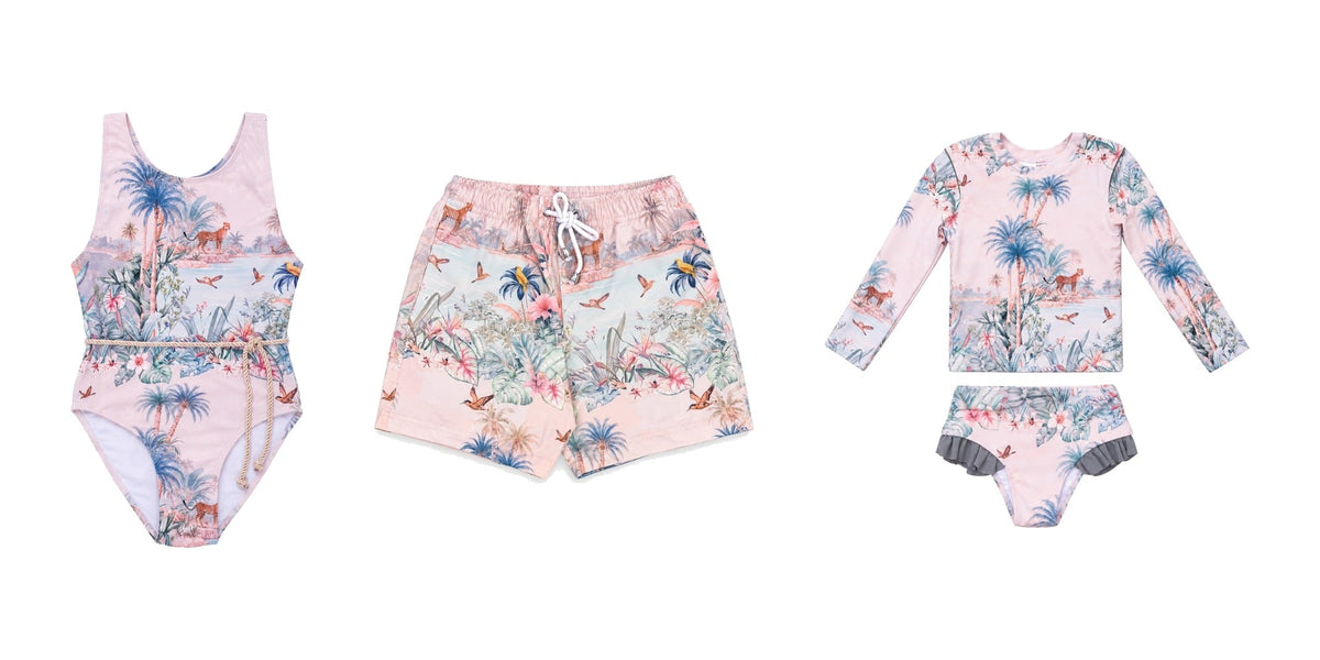 Matching sibling swimwear in a tropical print: girls’ one-piece, boys’ board shorts and long-sleeve rash set