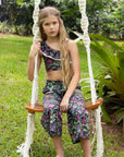 Girl wearing Olga Valentine Phoenix Wide Leg Pants and matching crop top on a garden swing
