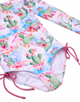 Close-up of the Taormina Bloom one-piece swimsuit showing the cactus floral print, lining and pink side ties.