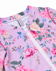 Close-up of the front zip, neckline and Olga Valentine label on the Girls Long Sleeve Zip One Piece in Violetta purple floral print
