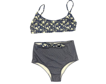 Olga Valentine Swimwear's Autumn Flowers Reversible Teen Bikini in Black. The top of the bikini features a light-coloured flower pattern on a black background. The bikini bottom features a tie front in the same design.